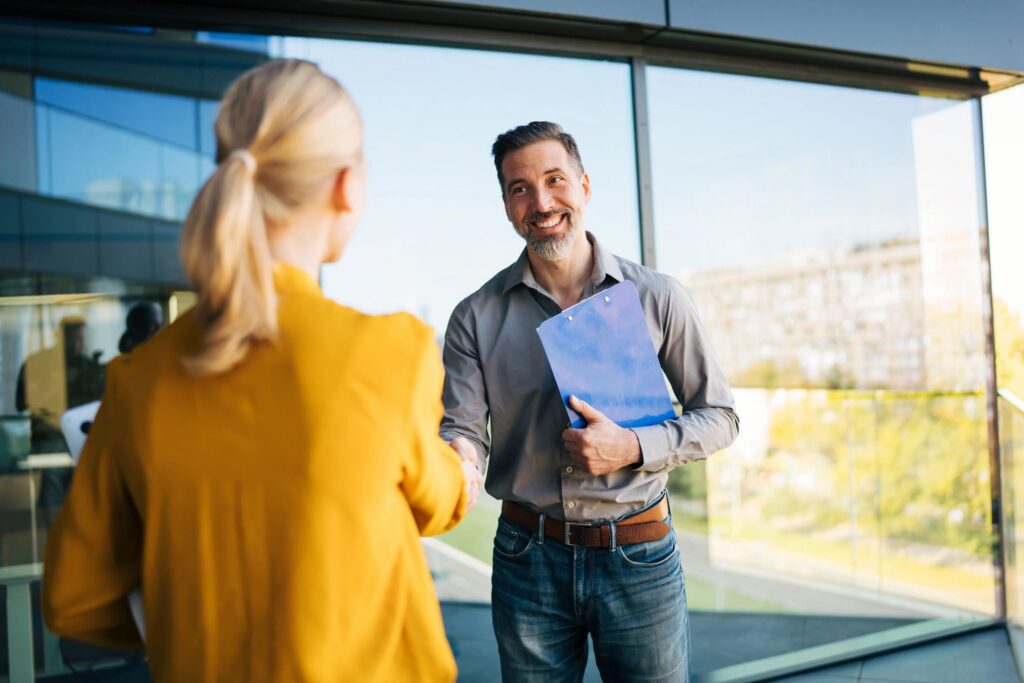 Business people shaking hands outside modern office building